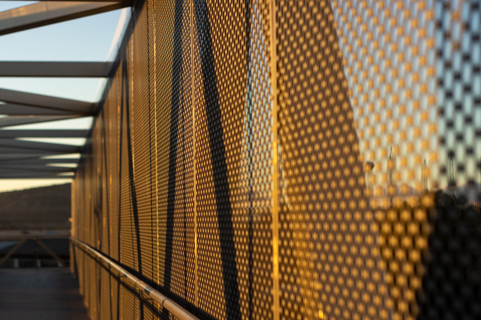 aluminum composite panels or cladding with perforated sheets on modern building facade on sunset, abstract architecture background concept.